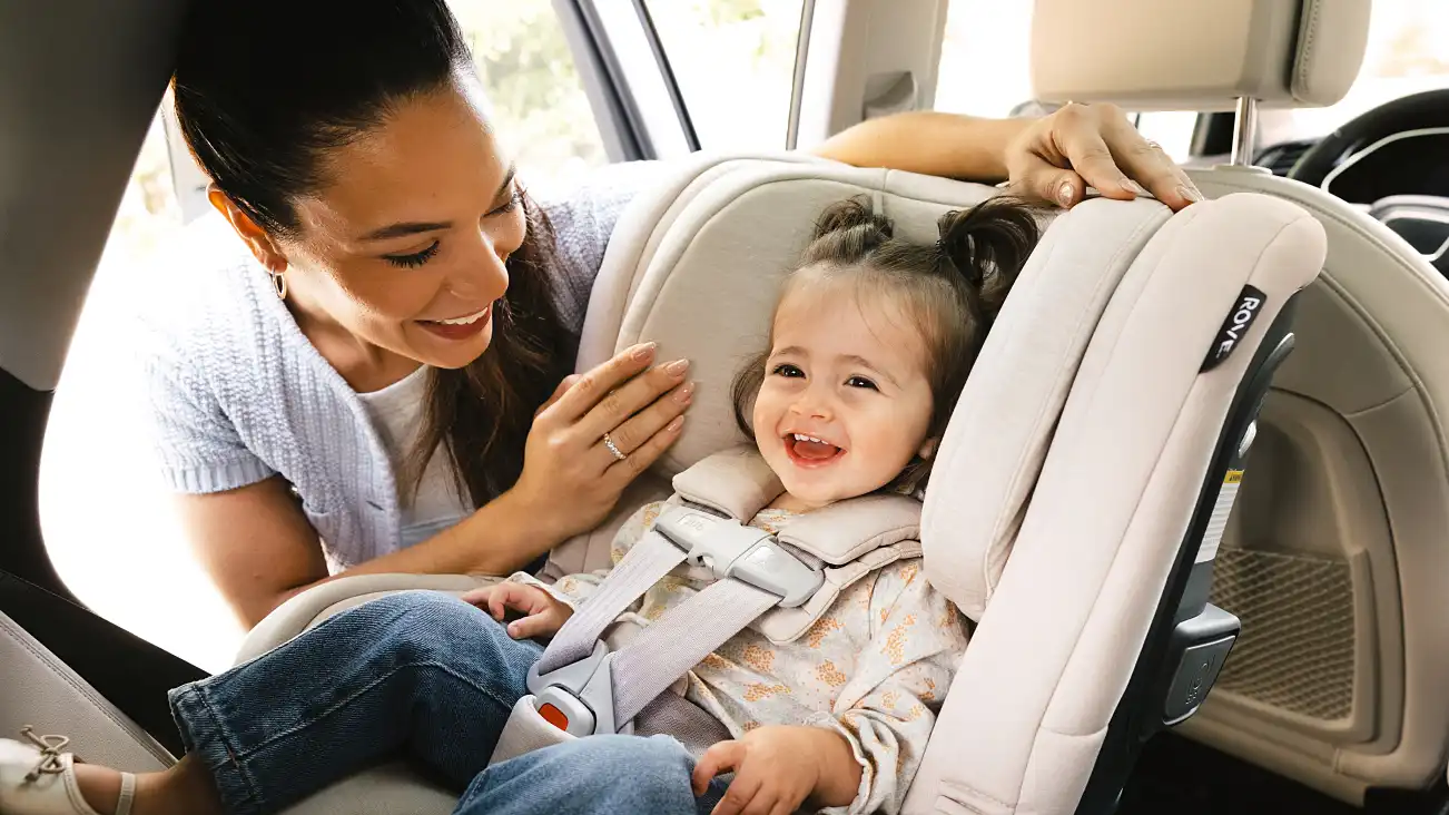 Parent adjusting headrest with smiling child