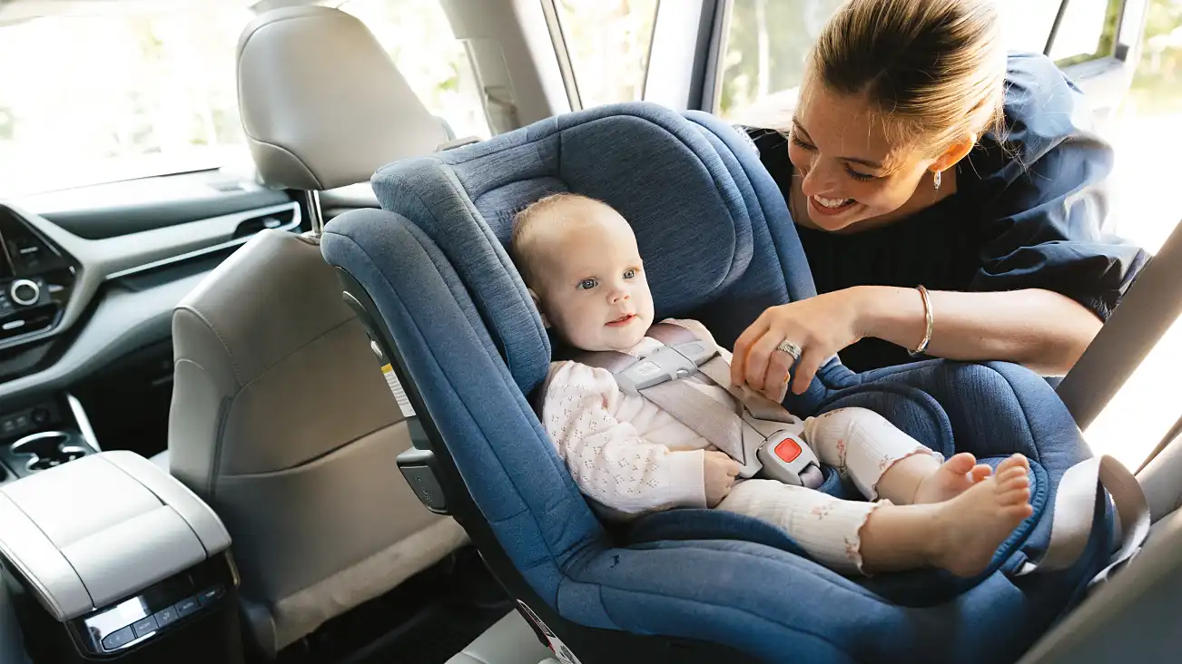 Parent secures infant in car seat